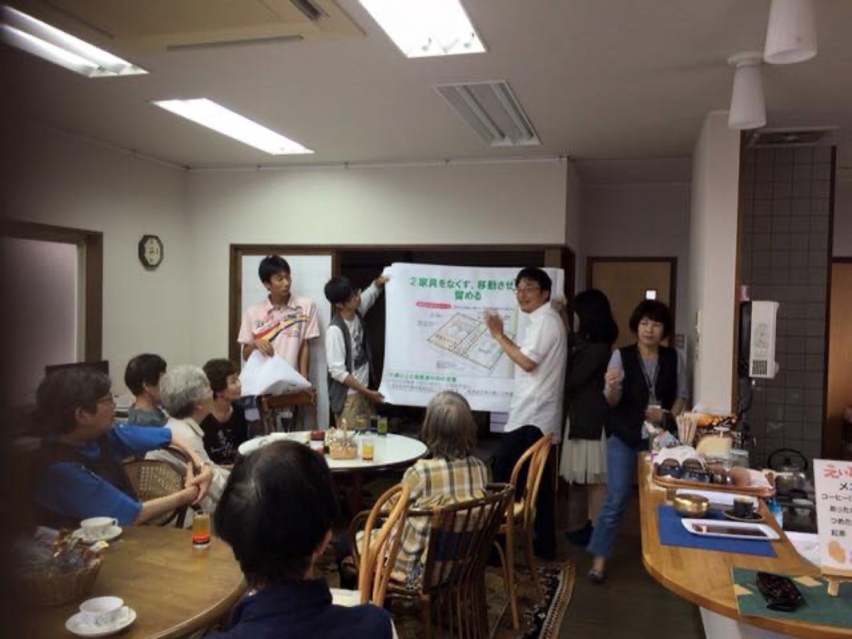 集会スペースで家具固定の大きな図を囲んで住民が学んでいる様子